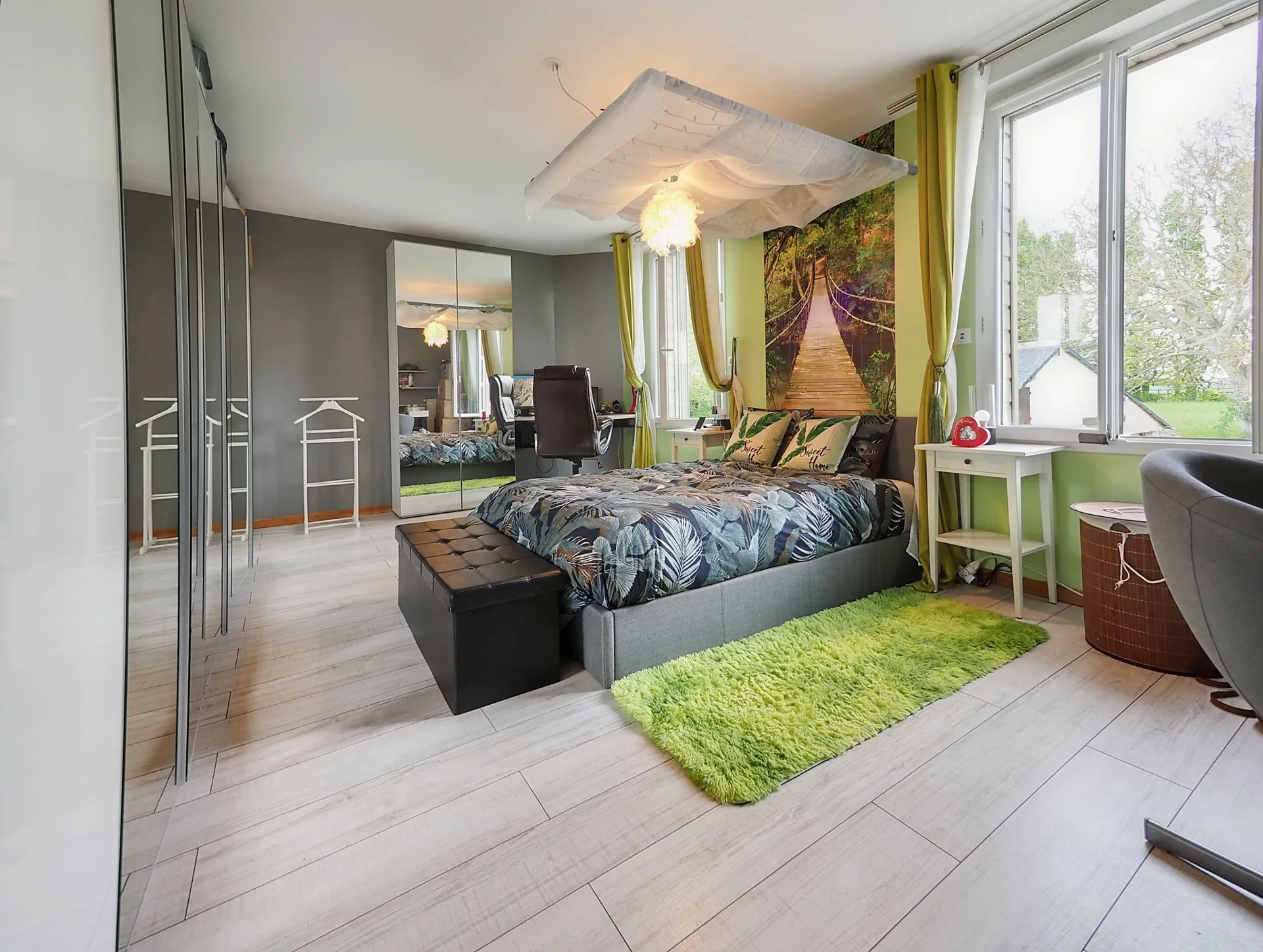 Chambre lumineuse avec lit double et grande armoire à miroirs